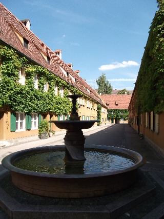 A street inside the Fuggerei showing the rows of ‘almshouses’ and the bronze bust of Jacob Fugger in the Fuggerei